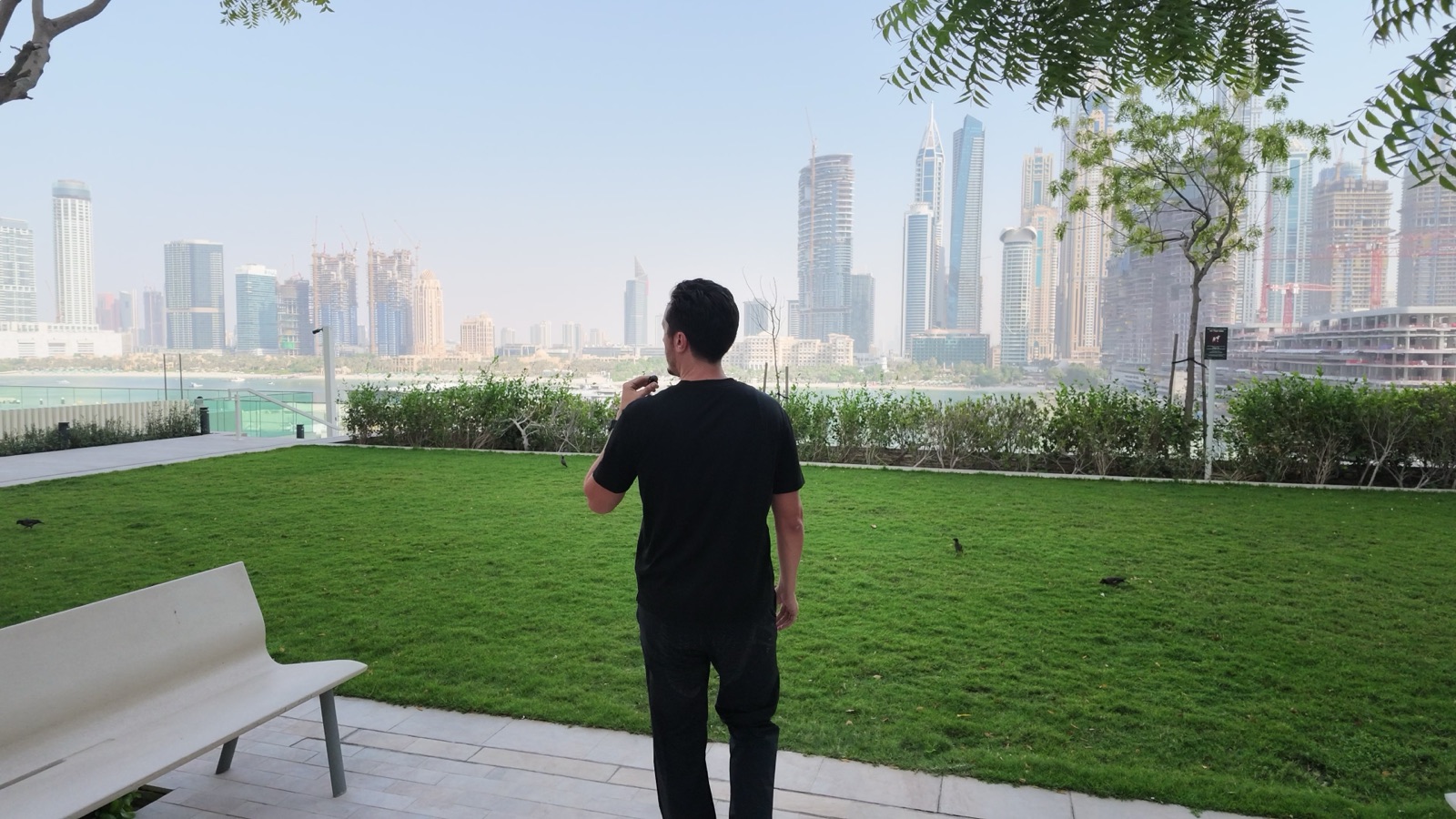 Clément Talmo dans le jardin d'une résidence, face aux tours de Dubai Marina